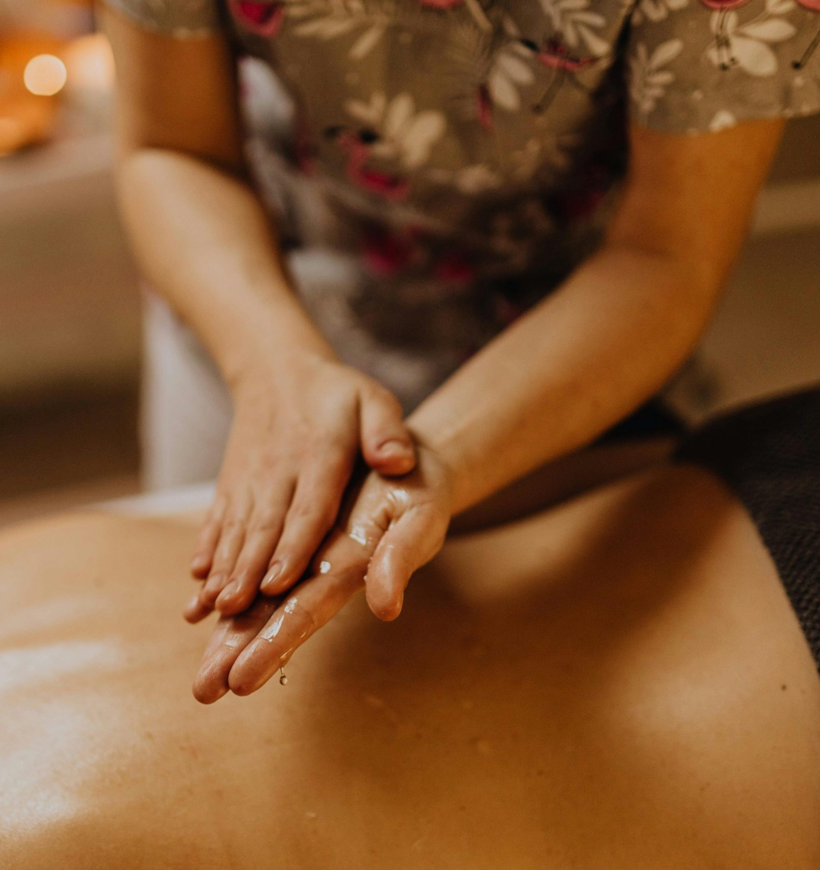 Personne allongée sur une table de massage, recevant un abhyanga, massage relaxant à l'huile chaude. Les mains de la praticienne glissent doucement sur la peau, créant une sensation de bien-être et de détente profonde. L'atmosphère est sereine, avec des lumières tamisées et une ambiance apaisante, idéale pour un moment de relaxation totale à Lunel-Viel près de Montpellier